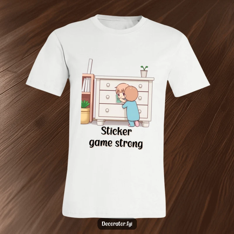 Funny t-shirt showing a determined character meticulously placing a small sticker onto furniture, embodying the spirit of careful home decoration.